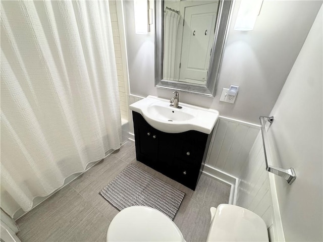5 Walnut Street Ext, Sennett, NY 13021 - bathroom featuring toilet, a wainscoted wall, shower / bathtub combination with curtain, and vanity
