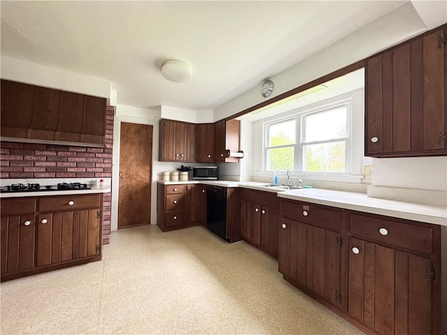 kitchen featuring black appliances, light countertops, dark brown cabinetry, and a sink