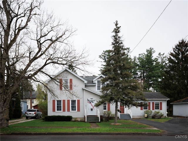 traditional home featuring a front yard and asphalt driveway
