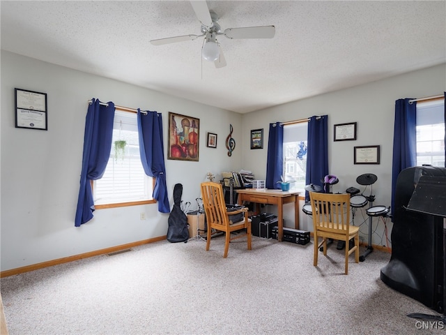 carpeted home office with a ceiling fan, a textured ceiling, and baseboards