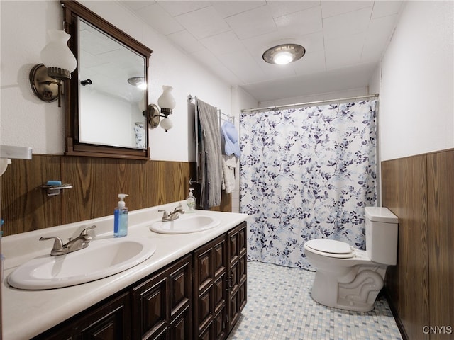 full bath featuring wainscoting, toilet, wooden walls, double vanity, and curtained shower