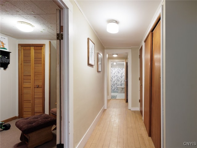 hallway featuring light wood-style floors and baseboards
