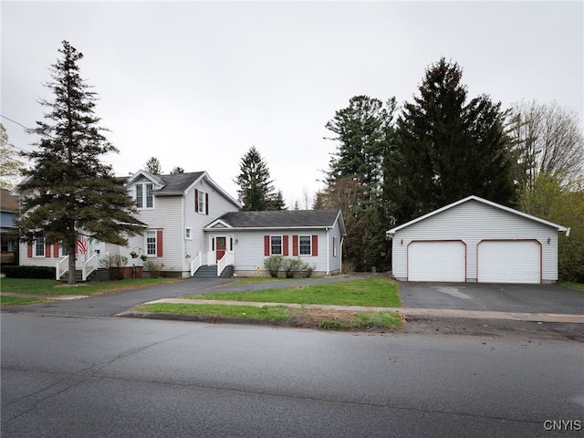 traditional-style house featuring a detached garage, an outdoor structure, and a front yard