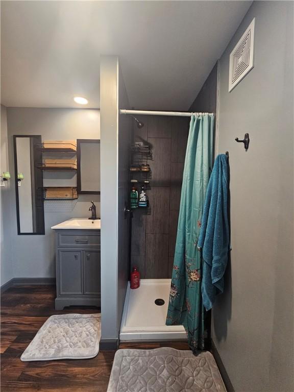57 Interstate Pkwy, Bradford-City, PA 16701 - bathroom with tiled shower, baseboards, wood finished floors, and vanity