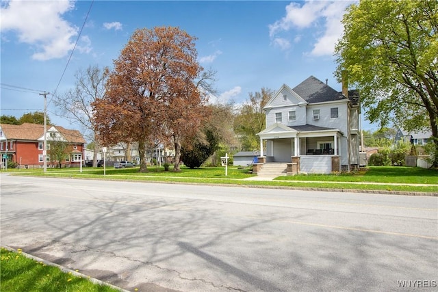 view of front of home with covered porch, a front yard, and a residential view