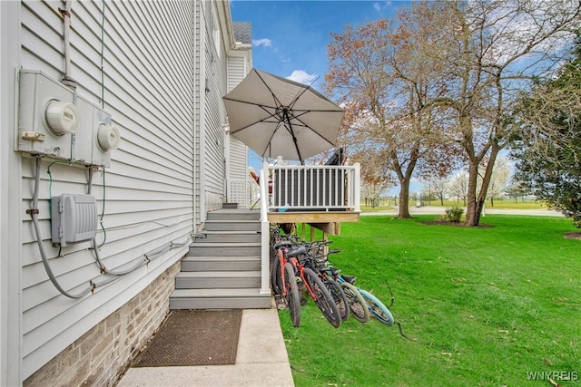 view of grassy yard featuring stairs and a deck
