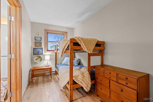 bedroom featuring light wood-style flooring and a baseboard heating unit