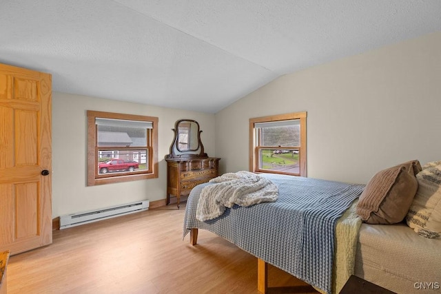 bedroom featuring baseboard heating, light wood-type flooring, vaulted ceiling, and a textured ceiling