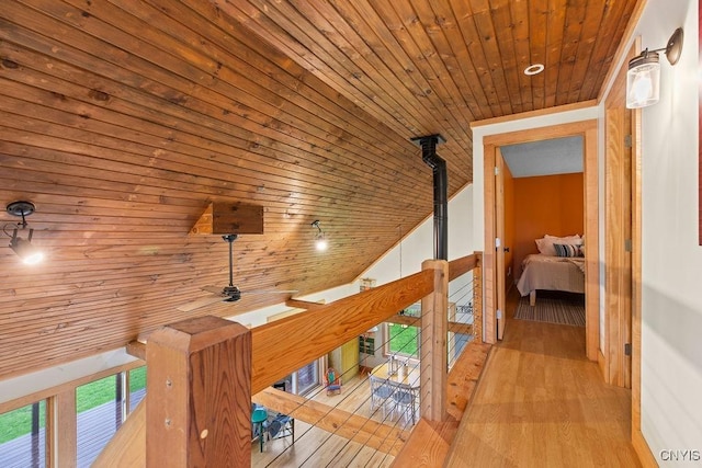 hall featuring wooden ceiling, an upstairs landing, healthy amount of natural light, wood finished floors, and lofted ceiling