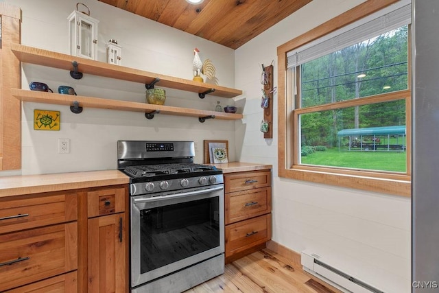 kitchen featuring stainless steel gas range oven, open shelves, a baseboard radiator, brown cabinetry, and light wood-style floors