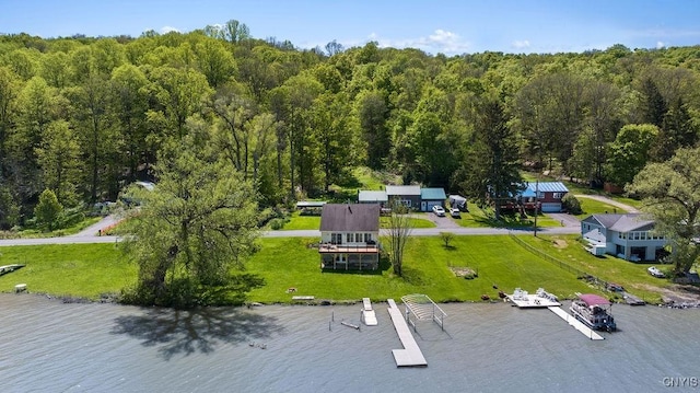 view of subject property with a nearby body of water and a heavily wooded area