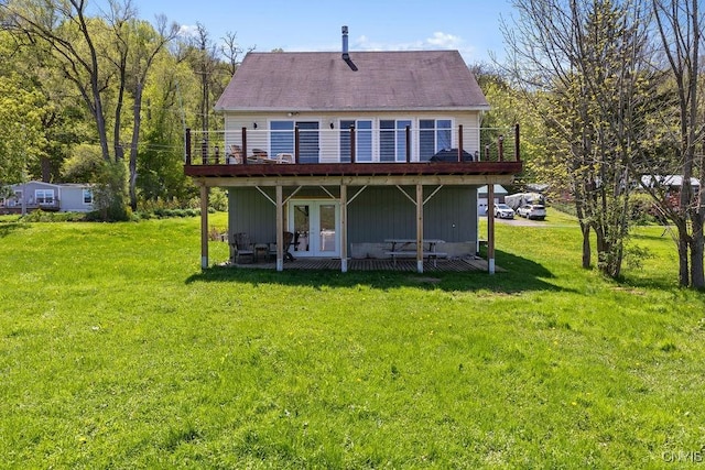 back of property featuring a deck, a yard, and french doors