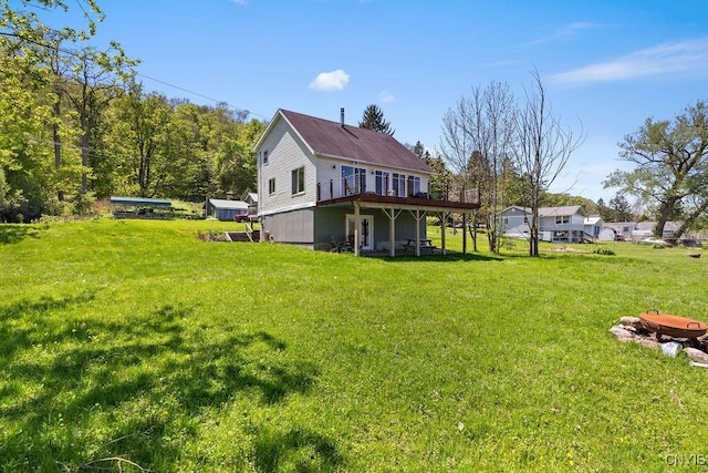 back of house featuring a wooden deck and a lawn