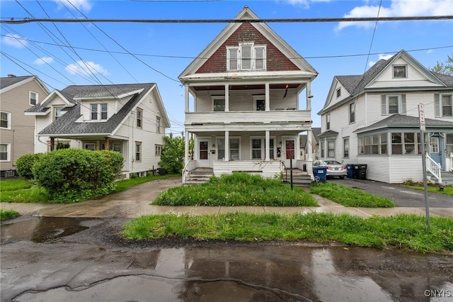 traditional style home with covered porch and a balcony