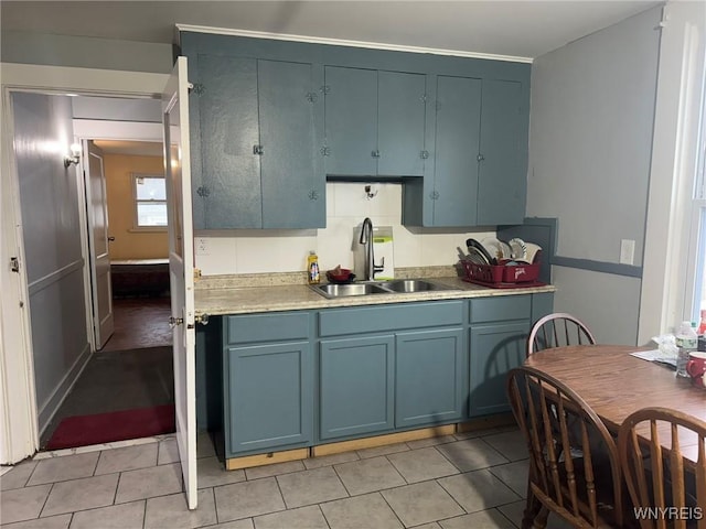 231 Grider St, Buffalo, NY 14215 - kitchen featuring a sink, light tile patterned floors, and blue cabinetry