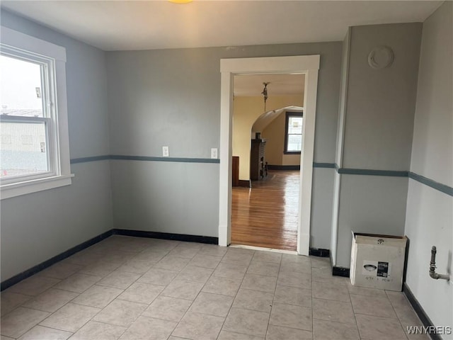 231 Grider St, Buffalo, NY 14215 - spare room with arched walkways, baseboards, and light tile patterned floors