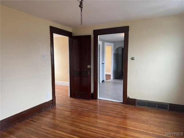 231 Grider St, Buffalo, NY 14215 - spare room with wood finished floors, arched walkways, and baseboards