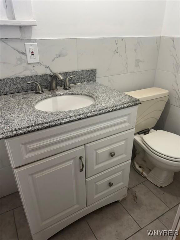 231 Grider St, Buffalo, NY 14215 - half bath with vanity, tile walls, toilet, and tile patterned flooring