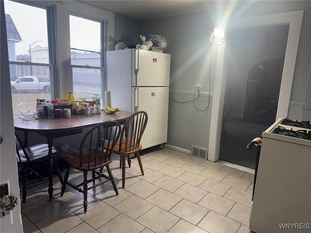 231 Grider St, Buffalo, NY 14215 - kitchen with white appliances, light tile patterned floors, and baseboards