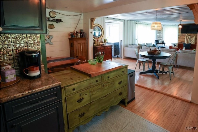285 Clinton St, Gouverneur, NY 13642 - kitchen featuring green cabinetry, healthy amount of natural light, light wood-type flooring, open floor plan, and wooden walls