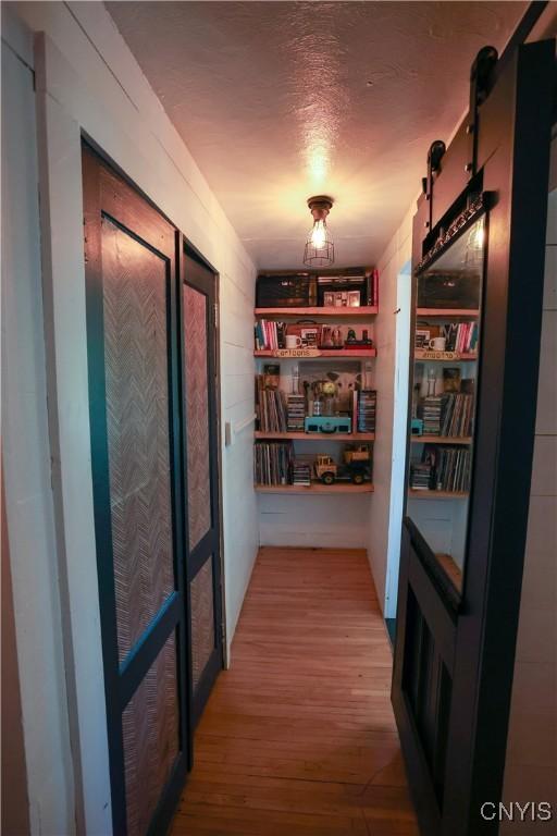 285 Clinton St, Gouverneur, NY 13642 - corridor with light wood-type flooring and a barn door