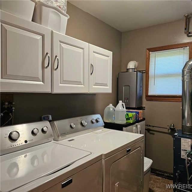washroom with washing machine and dryer, cabinet space, and tankless water heater