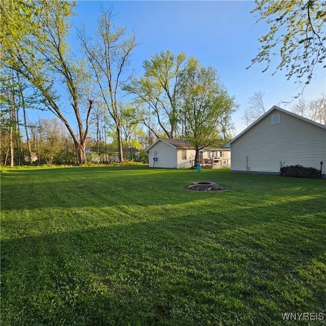 view of grassy yard featuring a fire pit