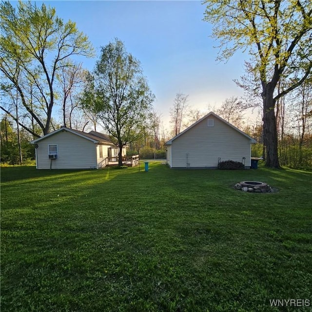 view of grassy yard with an outdoor fire pit