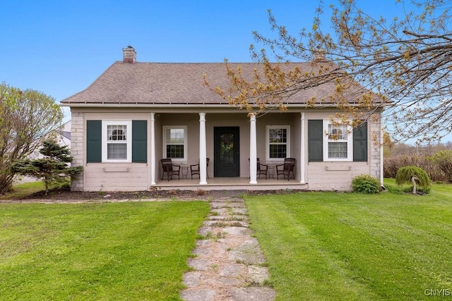 2066 Deerlick Rd, Cape Vincent, NY 13618 - view of front of house featuring a porch, a chimney, a front lawn, and roof with shingles