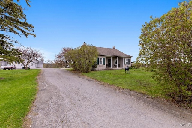 2066 Deerlick Rd, Cape Vincent, NY 13618 - ranch-style house featuring a front yard, a chimney, and driveway