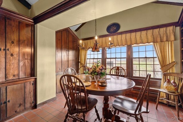 2066 Deerlick Rd, Cape Vincent, NY 13618 - dining room featuring tile patterned floors, lofted ceiling, a chandelier, and baseboards