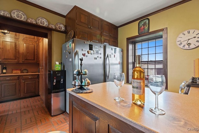 2066 Deerlick Rd, Cape Vincent, NY 13618 - kitchen featuring brick patterned flooring, light countertops, crown molding, and freestanding refrigerator