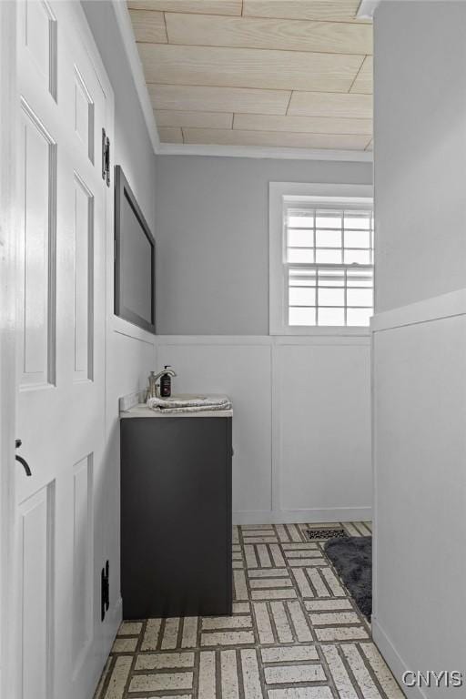 2066 Deerlick Rd, Cape Vincent, NY 13618 - bathroom with wooden ceiling, brick patterned flooring, vanity, and wainscoting