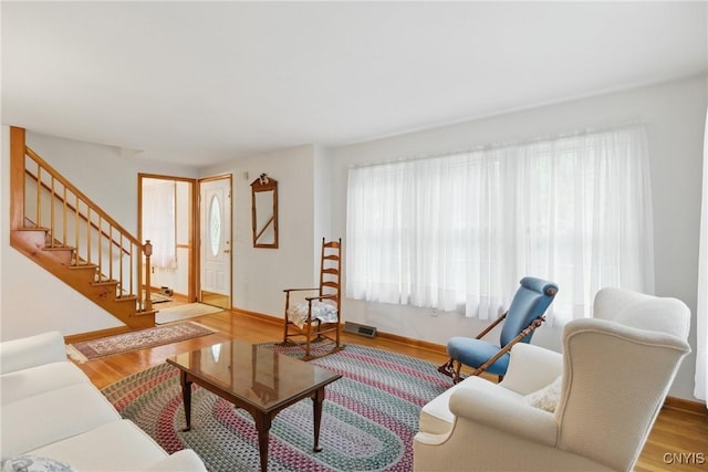 106 Lee Ter, Manlius, NY 13057 - living area featuring plenty of natural light, stairway, and wood finished floors