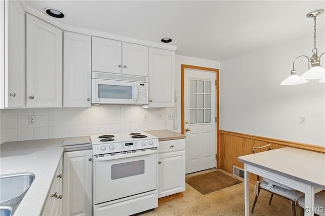 106 Lee Ter, Manlius, NY 13057 - kitchen with white appliances, white cabinetry, light countertops, a wainscoted wall, and wooden walls