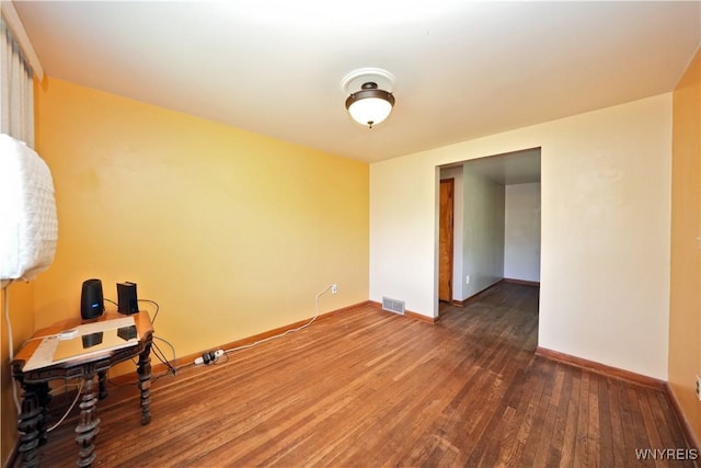 empty room with baseboards and wood finished floors