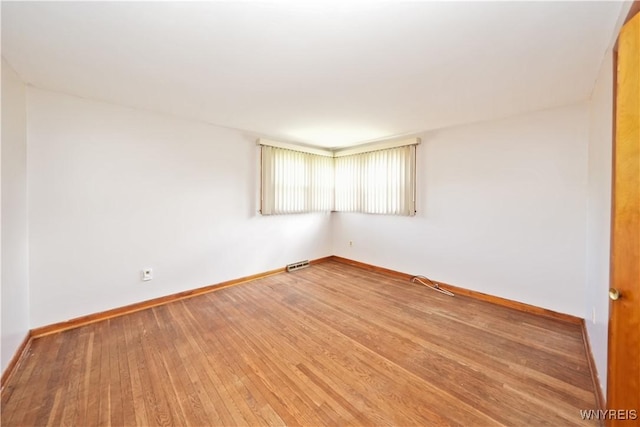 unfurnished room featuring wood finished floors and baseboards