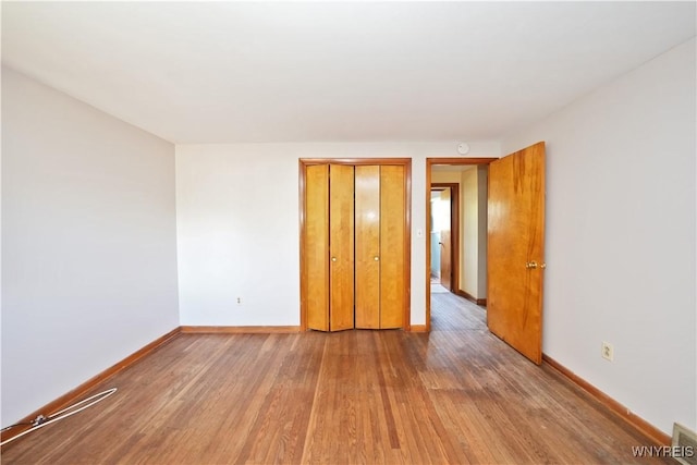 unfurnished room featuring wood finished floors and baseboards