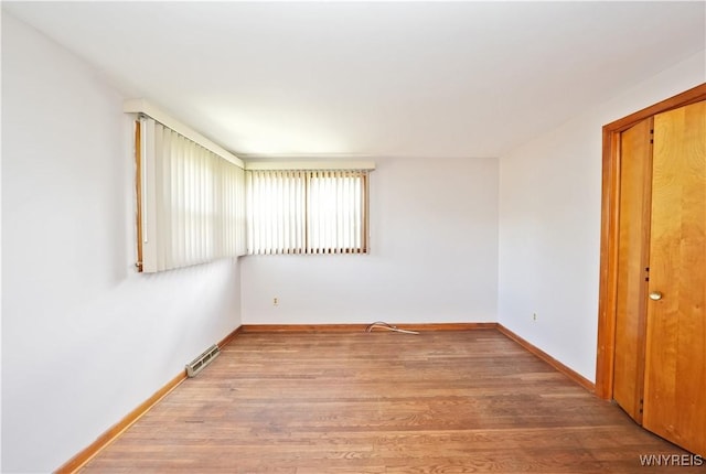 spare room featuring wood finished floors and baseboards