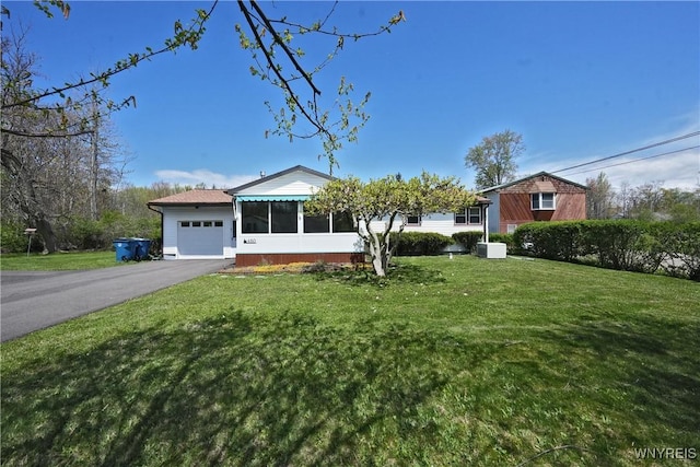 ranch-style home with a garage, asphalt driveway, and a front yard