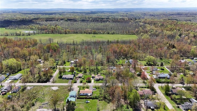 aerial overview of property's location with a forest and nearby suburban area