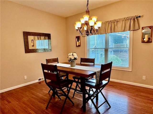 dining space with a chandelier, hardwood / wood-style floors, and baseboards