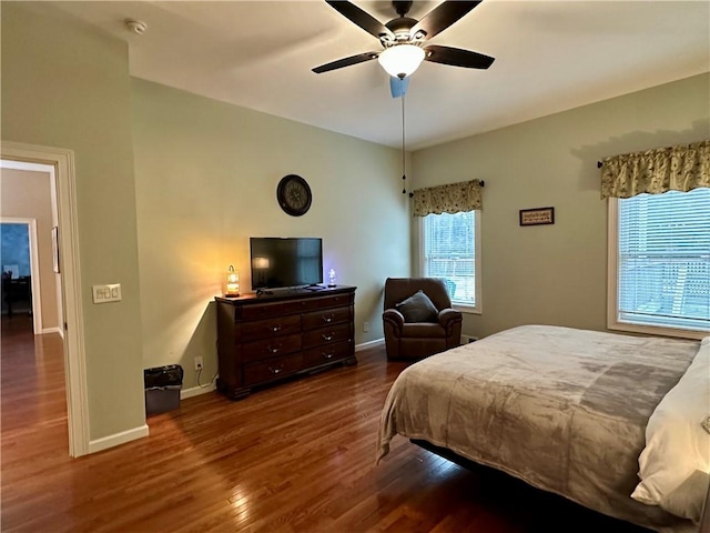 bedroom featuring wood finished floors, baseboards, and ceiling fan