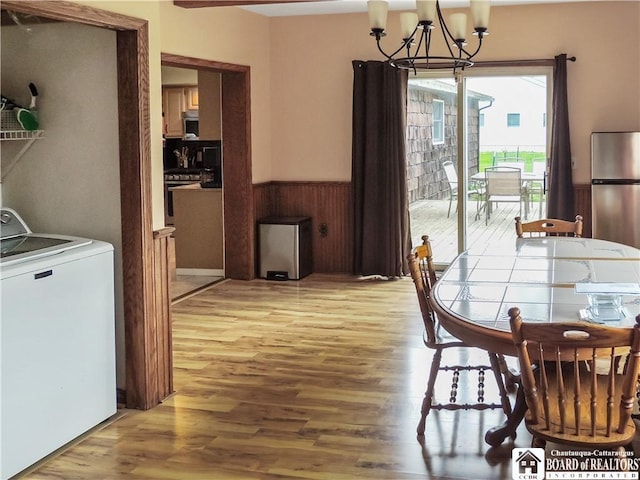 3830 E Ross Mills Rd, Ellicott, NY 14733 - dining space featuring washer / dryer, light wood-style floors, a chandelier, and a wainscoted wall