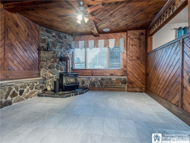 3830 E Ross Mills Rd, Ellicott, NY 14733 - unfurnished living room featuring wooden ceiling, ceiling fan, a wood stove, and wood walls