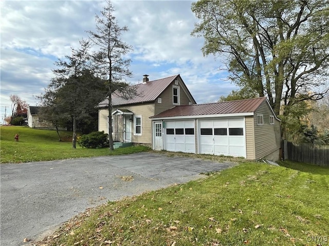 43815 Stine Rd, Alexandria, NY 13679 - view of front facade featuring asphalt driveway, metal roof, a chimney, and a garage