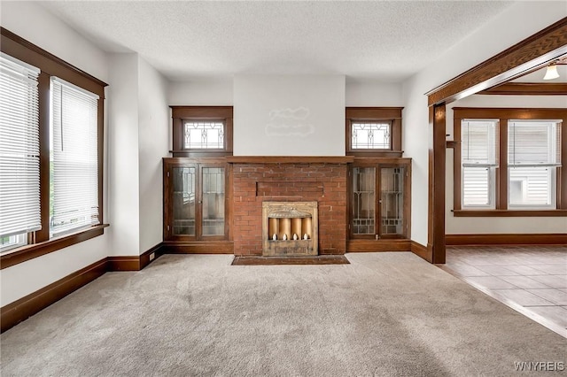 61 Norwalk Ave, Buffalo, NY 14216 - unfurnished living room with carpet floors, a fireplace, a textured ceiling, baseboards, and tile patterned flooring
