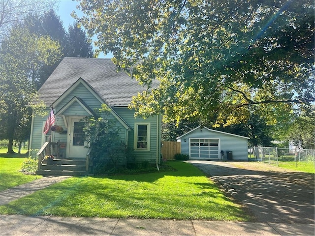 view of front of property with driveway, a garage, a shingled roof, and an outbuilding