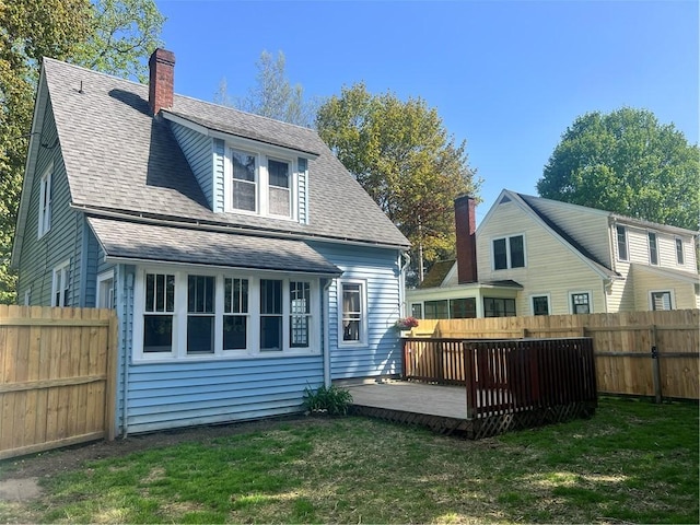 rear view of house featuring a chimney and roof with shingles