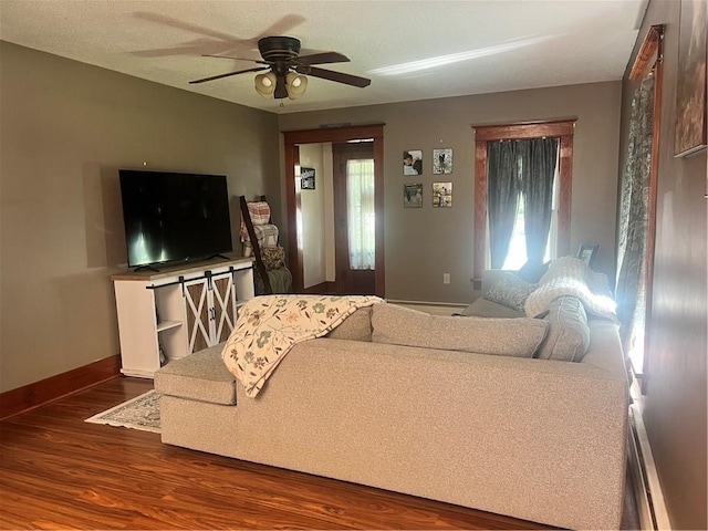 living room featuring dark wood-type flooring, a ceiling fan, and baseboards
